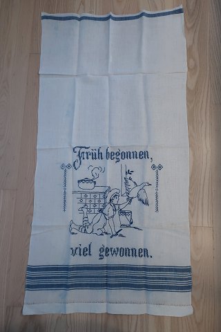 Parade pieceA beautiful old parade piece with handmade blue embroideryTekst: "Früh begonnen viel gewonnen" (To begin early is well succeded)109cm x 55cmThe antique, Danish linen and fustian is our speciality