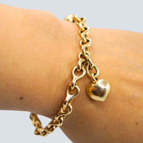 Ole Lynggaard; Otte-tals armbånd i 14 kt. guld med smilet kuglelås og hjertevedhæng