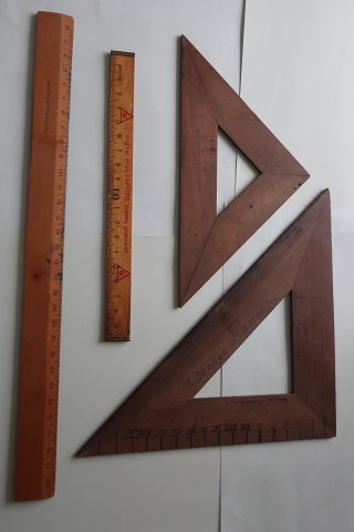 Ældre tegneredskaber af træ, som i gamle dage
2 vinkler/trekanter (en lille og en stor) og 2 linealer i 2 størrelser
Ingen stemplet tekst på vinklerne/trekanterne
Stor lineal stemplet: "Albert Nestler A.-G."
Lille lineal med reklametekst