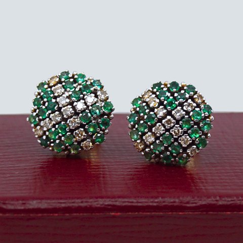 A pair of round earrings in 14kt gold set with diamonds and emeralds