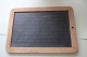 An old blackboard/slate mad of slate with an edge 
of wood