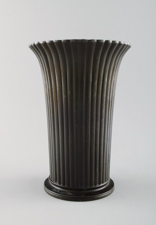 Just Andersen: f. Godhavn, Grønland 1884, d. Glostrup 1943.  Vase af patineret diskometal, støbt med vertikalt riflet mønster.