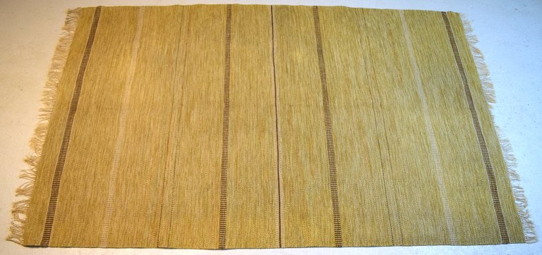 Svensk tekstildesigner. Stort håndvævet tæppe i ren bomuld. Stribet design på sennepsgul baggrund. 1960