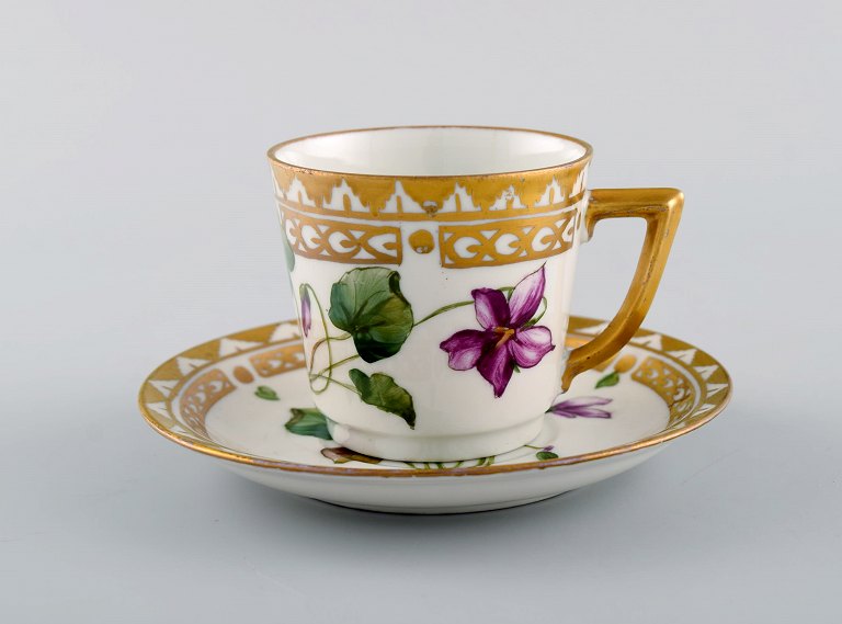 Royal Copenhagen kaffekop med underkop i håndmalet porcelæn med gulddekoration og blomster. Flora danica stil, 1960
