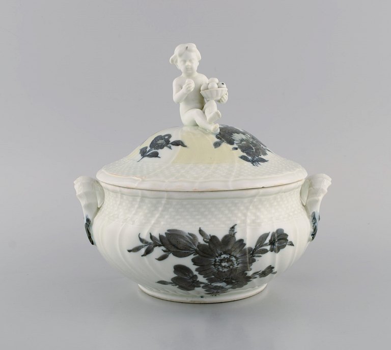 Tidlig Royal Copenhagen Blå Blomst Svejfet lågterrin i porcelæn med håndmalede blomster. Låg modelleret med frugtspisende putti. Ca. 1820.