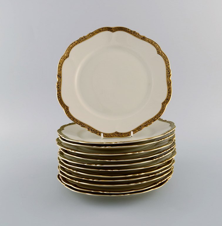 KPM, Berlin. Tolv Royal Ivory frokosttallerkener i cremefarvet porcelæn med gulddekoration. 1920