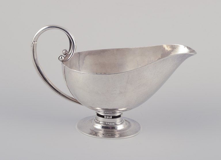 Johan Rohde (1856-1935) for Georg Jensen. Sovsekande af sterlingsølv. Hammerslået kande med hank og på oval fod.